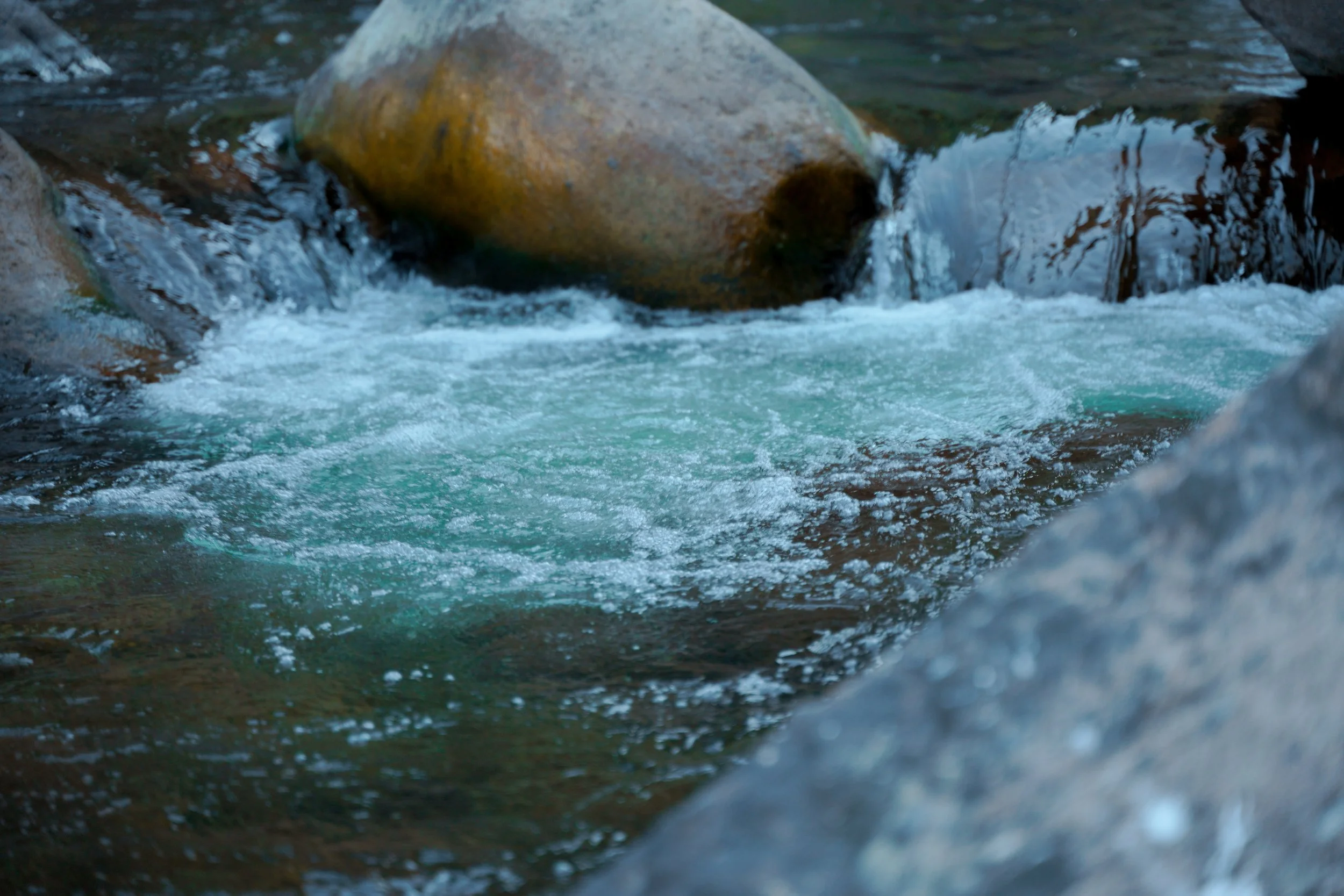 Water flowing between river stones